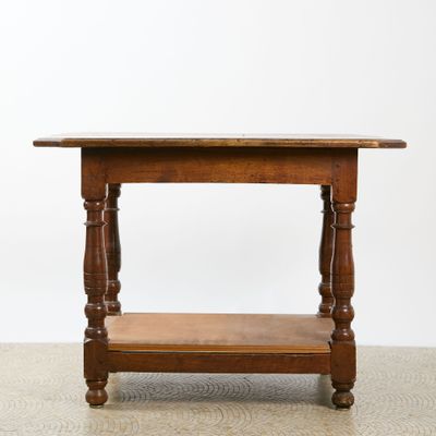 an old wooden table with a shelf on top of it