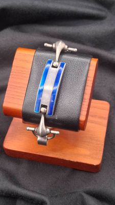 a black wallet with a blue stripe on it on a wooden stand