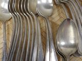 a lot of silver spoons and spoon spoons on a tray