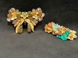 two pieces of brooches are sitting on a black surface