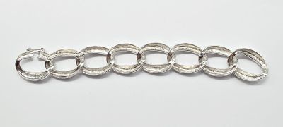 a close up of a silver bracelet on a white surface