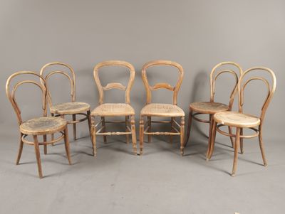 quatre chaises sont alignées en rang contre un mur gris