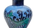 un vase bleu orné d'une peinture sur fond blanc