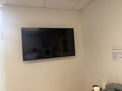 une télévision à écran plat fixée au mur dans un coin de la pièce