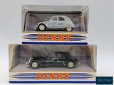 two boxed boxes of die - cast cars, one in black and one in white