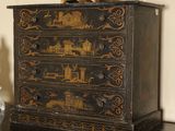a small chest of drawers with a clock on top of it
