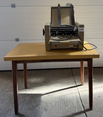 une machine à écrire posée sur une table devant la porte d'un garage