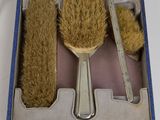 three brushes and a brush in a box on a table