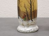 a vase with a painting on it sitting on a table
