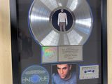 framed picture of a silver disc with a picture of a man in a white shirt