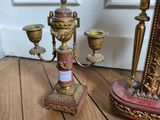 candlesticks and a mirror on a wooden floor in front of a door