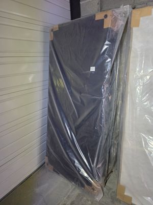 two pieces of furniture wrapped in plastic in a warehouse
