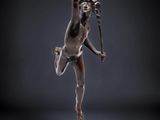 une statue en bronze représentant une femme tenant un serpent, posée sur un socle
