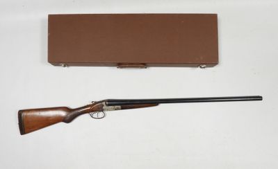 un vieux fusil et une boîte posés sur une surface blanche