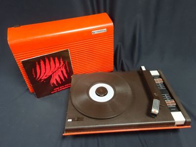 an orange box with a record on top of it next to a record player