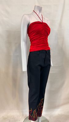 Le mannequin porte un haut rouge et un pantalon noir.