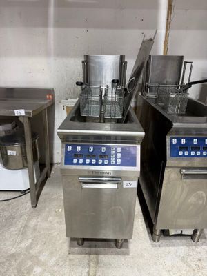 two deep fryers in the middle of a kitchen