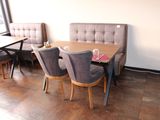 a table with chairs and a bench in the corner of the room