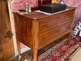 a dresser in the corner of a room with a red wallpaper