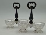 three glass bowls and a bottle opener on a white surface