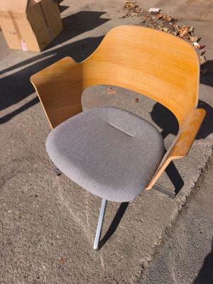 une chaise posée sur le trottoir devant des cartons