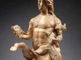 une statue en bronze d'une femme tenant un oiseau sur un piédestal