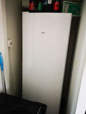 un réfrigérateur blanc dans le coin d'une pièce