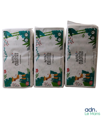 trois paquets de papier toilette posés les uns à côté des autres