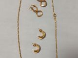 un collier et des boucles d'oreilles en or sont présentés sur un fond blanc