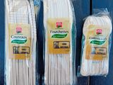 three bags of white cotton are sitting on a wooden table