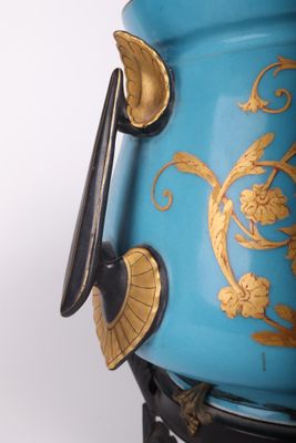 a blue vase with gold decoration on it on a stand