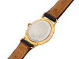 a close up of a watch on a white surface with a brown strap