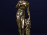 une statue en bronze représentant une femme tenant un sac