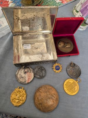 une table sur laquelle se trouvent une boîte en argent et un tas de pièces d'or