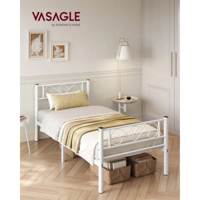 un lit blanc recouvert d'une couverture jaune et blanche