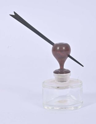 a small glass jar with a wooden handle on it