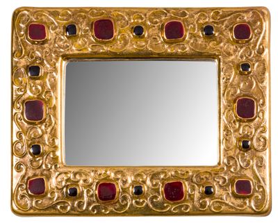 une image représentant un miroir en or orné de pierres rouges et noires