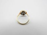 a close up of a gold ring with a black diamond