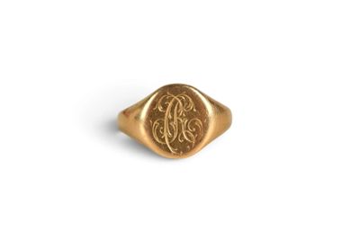 a close up of a gold signet ring with a monogram on it