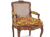une image représentant une chaise en bois dont l'assise est ornée d'un motif jaune et rouge