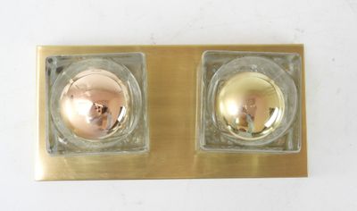 two gold colored candles sitting on top of a gold plate