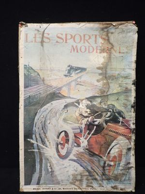 un vieux livre avec l'image d'un homme au volant d'une voiture sur un circuit