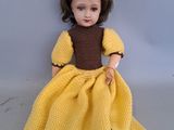 poupée au crochet jaune, avec une robe et des chaussures marron