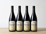 trois bouteilles de vin sont alignées sur une table en bois