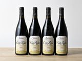 trois bouteilles de vin sont alignées sur une table en bois