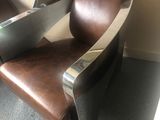 a brown leather chair with a laptop on top of it