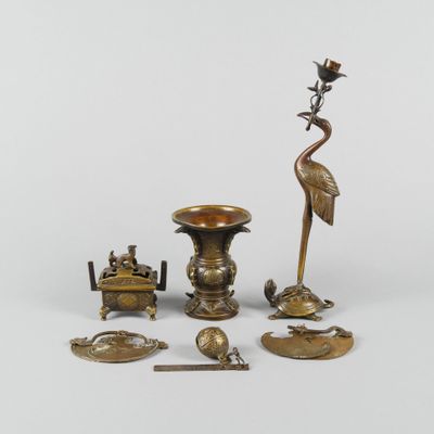 an assortment of brass objects including a bird, a candle, a bowl, and a spoon