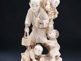 figurine en ivoire représentant un homme avec un enfant et deux autres enfants