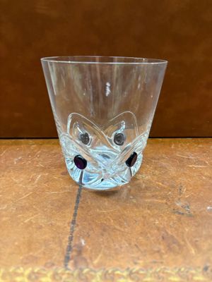 un verre orné d'un visage, posé sur une table