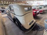 many old cars parked in a garage with other cars in the background